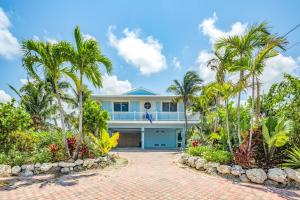 a house with palm trees and a driveway at CJ286FLR LUX-Parrotfish Point in Cudjoe Key