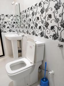 a bathroom with a white toilet and a sink at Ceylon Beach haven Uppuveli in Trincomalee +32 photos