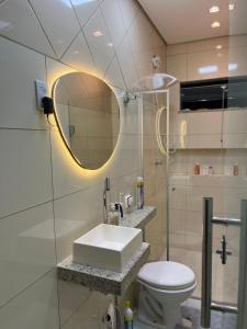 a bathroom with a sink and a toilet and a mirror at Casa Nova, 2 quartos, 1 Ar-Cond, 1 Banheiro, Garagem 4,30m in Montes Claros +34 photos
