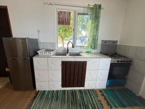a small kitchen with a sink and a refrigerator at Ohotu Lodge in Rangiroa
