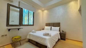a bedroom with a bed with a mirror and a window at Villa familiale avec piscine privée sans vis à vis in Oulad Raho +10 photos