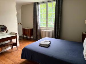 a bedroom with a blue bed and a window at Maison de famille - Proche Centre Ville et Plage in Cabourg
