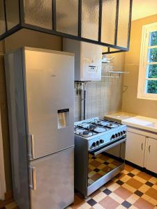 a kitchen with a refrigerator and a stove at Maison de famille - Proche Centre Ville et Plage in Cabourg
