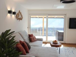 a living room with a couch and a large window at Apartment Bergliebe in Sellrain