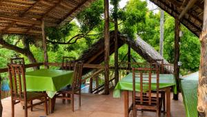a restaurant with a table and chairs and a tree at Ceylon Beach haven Uppuveli in Trincomalee