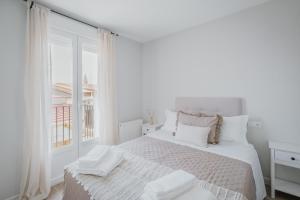 a white bedroom with a large bed and a window at Casa Da Rita in Matapozuelos