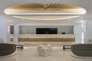 a large lobby with a television and a large ceiling at Paradise Resort Evia, a member of Radisson Individuals in Eretria