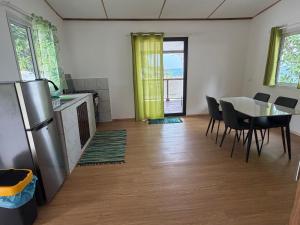 a kitchen and dining room with a table and chairs at Ohotu Lodge in Rangiroa