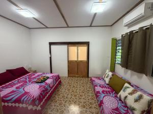 a bedroom with a large bed and a couch at Ohotu Lodge in Rangiroa