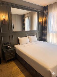 a bedroom with a large white bed with a window at Peri Boutique Hotel Taksim in Istanbul