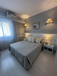 a bedroom with a large bed with two tables and two lamps at Hotel Valles in Mar del Plata