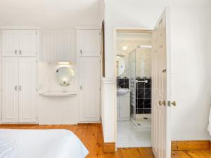 a white bathroom with a shower and a white bed at Conamara House in Ballyconneely +44 photos