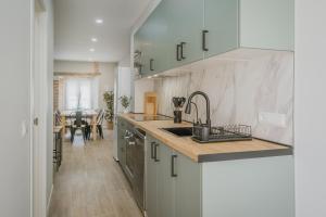 a kitchen with white cabinets and a sink and a table at Casa Da Rita in Matapozuelos