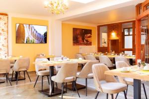 a restaurant with tables and chairs and a chandelier at Hotel am Katharinenholz in Potsdam