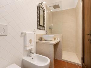 a white bathroom with a sink and a toilet at Panoramic Sea View Apt 4 Close to the Beach With Pool in Baja Sardinia +26 photos