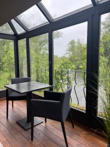a room with a table and chairs and windows at Maison Camille in Hotton