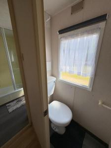 a small bathroom with a toilet and a window at Domki Dolce Vita in Jastarnia +23 photos