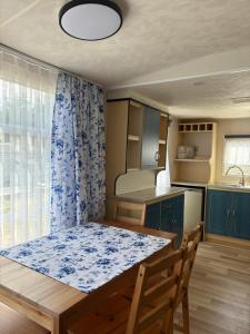 a kitchen with a wooden table and a blue curtain at Domki Dolce Vita in Jastarnia