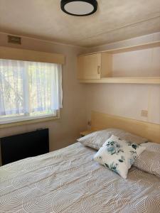 a bedroom with a bed with a pillow and a window at Domki Dolce Vita in Jastarnia