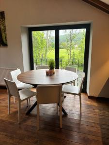 a dining room with a table and chairs and a window at Maison Camille in Hotton +7 photos