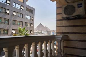 a balcony of a building with a view of a pyramid at Gold's Pyramids Hotel in Cairo