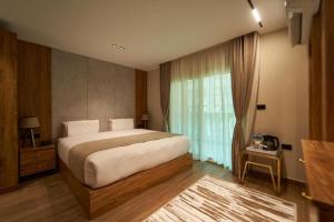 a bedroom with a large bed and a large window at Gold's Pyramids Hotel in Cairo