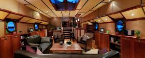 a train room with a couch and a table at Péniche - Eden in Samois-sur-Seine