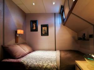 a small bedroom with a bed in the corner at Péniche - Eden in Samois-sur-Seine