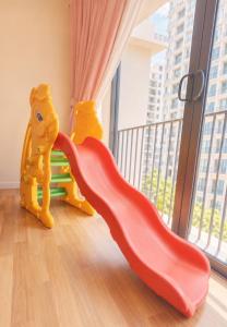 a pair of red shoes and a slide in front of a window at Minimalist Studio Trefoil Setia Alam linked bridge to Mall and Convention Centre near to NIH Peninsula in Setia Alam