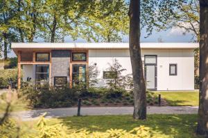 a white house with trees in front of it at Vakantiepark Ackersate in Voorthuizen