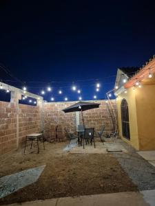 a patio with a table and an umbrella at night at Family vacation, comfortable space in Zacatecas