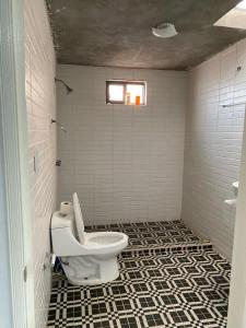 a bathroom with a toilet and a tiled floor at Family vacation, comfortable space in Zacatecas