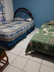 two beds sitting on a tiled floor in a room at Family vacation, comfortable space in Zacatecas