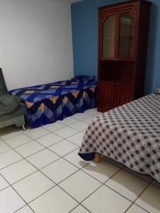 a bedroom with two beds and a cabinet and a tiled floor at Family vacation, comfortable space in Zacatecas +3 photos