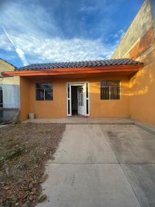 a small orange house with a white door at Family vacation, comfortable space in Zacatecas