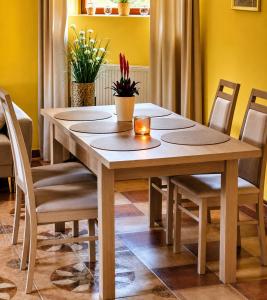 a dining room table and chairs with yellow walls at Apartament Biała Flaga Podwórko, Grill, Rowery in Charzykowy