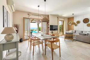 a dining room and living room with a table and chairs at Villa AmberBlue Kalathos in Kalathos