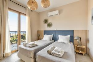 a bedroom with two beds with towels on them at Villa AmberBlue Kalathos in Kalathos +22 photos