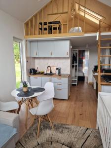 a kitchen and living room with a table and chairs at Leśny Staw Stodoła in Gilwa