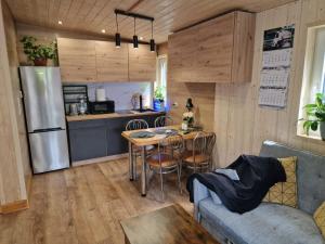 a kitchen and living room with a table and a refrigerator at Leśny Staw Stodoła in Gilwa +24 photos