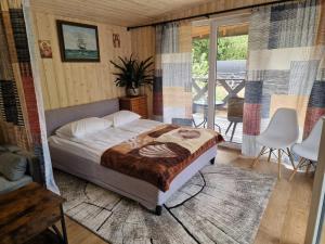 a bedroom with a bed and a balcony at Leśny Staw Stodoła in Gilwa