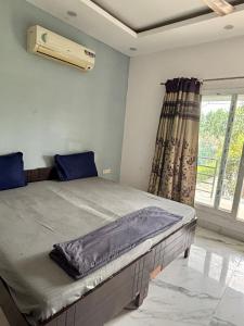 a bedroom with a large bed with a window at GoBravo 48 - 2BHK Farm with Pool and Garden Sector 150 Noida in Greater Noida +34 photos