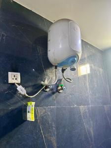 a machine is plugged into a wall in a room at GoBravo 48 - 2BHK Farm with Pool and Garden Sector 150 Noida in Greater Noida