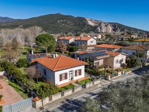 a house with an orange roof in a suburb at Hostly The Citrus Garden in Cascina