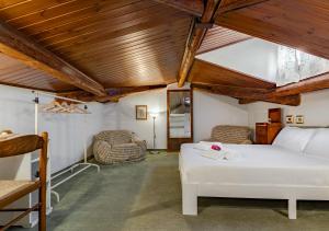 a bedroom with a white bed and wooden ceilings at Hostly The Citrus Garden in Cascina