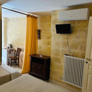 a bedroom with a bed and a tv on a wall at Santa Cesarea Sassi in Matera