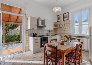 a kitchen with a wooden table and a table and chairs at Hostly The Citrus Garden in Cascina