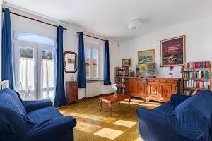 a living room with two blue chairs and a table at Hostly The Citrus Garden in Cascina