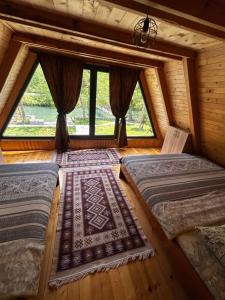 two beds in a room with a window at Vikendica Mia in Šipovo