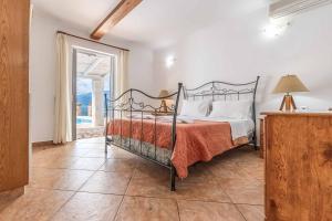 a bedroom with a bed and a large window at Villa Morfeas in Nydri